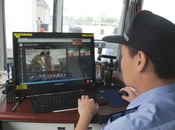 A Qingdao police officer uses facial recognition technology to cross-reference an image with pictures in a database.(Feng Kaiming/for China Daily)