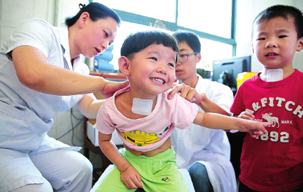 People queue to receive sanfutie plasters. Chinese generally believe receiving treatment when the weather is warm will help cure illness more effectively. (Photo/China Daily)