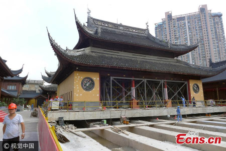 The main pavilion of Shanghai��s Jade Buddha Temple will be shifted 30 meters northward on September 2, 2017. Mahavira Hall, built in 1918, will be moved along with three huge Buddhist statues and other cultural heritages inside. Shanghai Construction No. 4 Group added never before has such an operation been attempted with a temple in China. The moving project along with other renovations are aimed at creating more room for worshippers and to address fire and other safety concerns at the popular historic temple in Anyuan Road. The project is expected to be completed in two weeks when some 500 square meters of space will be released in the main square, doubling its current size, for worshipers and visitors to pray, said Shen Junqi, the project manager. Other pavilions and halls will remain open during the project. (Photo/Agencies)
