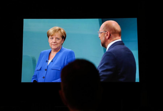 A man watches the TV duel between German Chancellor Angela Merkel and Martin Schulz, chancellor candidate of the Social Democratic Party (SPD), at a media center in Berlin, Germany, Sept. 3, 2017. (Xinhua/Shan Yuqi)