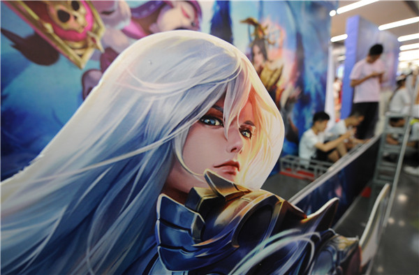 People gather at a department store to watch and play in a King of Glory challenge held by the store in Shanghai. (Photo by Li Sanxian, Yin Ming and Wang Gang/For China Daily)