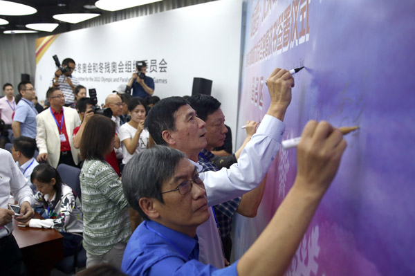 Representatives of 50 overseas Chinese media outlets sign their names in support of the Beijing 2022 Winter Olympic Games and Paralympic Games on Thursday. (Photo by ZOU HONG/CHINA DAILY)
