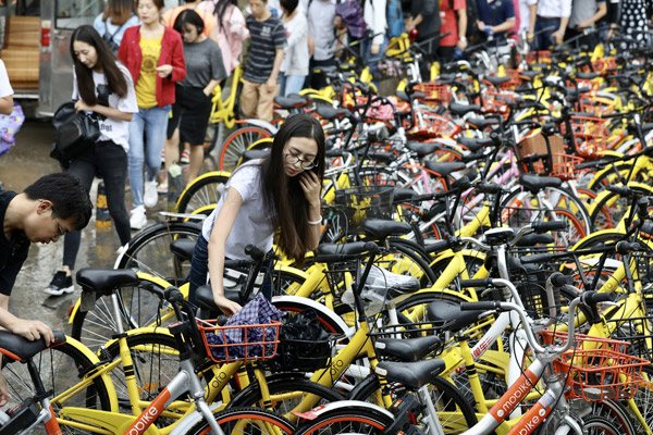People face a jungle of shared bikes near the Lishuiqiao subway station in Beijing in June. (Photo by ZHU XINGXIN/CHINA DAILY)