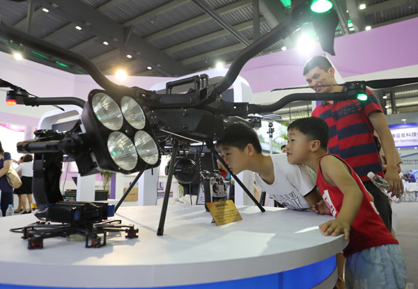Children take a close look at an industrial drone at the 2017 World Internet of Things Wuxi Summit on Sept 10, 2017. (Photo by GAO ERQIANG/CHINA DAILY)