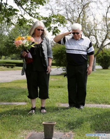 Gail Cooper Baumgartner-Brown (L) and her husband William Brown place a bunch of flowers on the tomb of her father Joseph Cooper in the suburb area of Chicago, the United States, on Aug. 18, 2017. (Xinhua/Wang Ping)