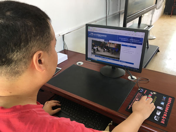 A visitor scrolls through the website of the poverty alleviation data system, Sept 10, 2017. (Photo:chinadaily.com.cn/Wang Jingjing)