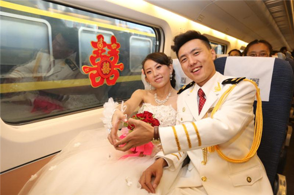 Chen Dong and Ma Yan pose for a photo on Train No D6907 during their wedding on Saturday. (Photo by Bo Yanhui/For China Daily)