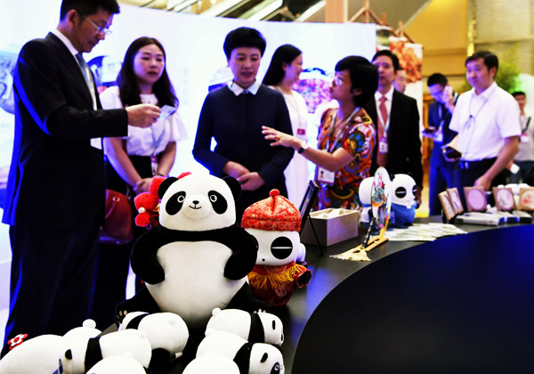 UN World Tourism Organization assembly attendees look over promotional products in Chengdu, Sichuan province, on Wednesday. (Photo by AN YUAN/CHINA NEWS SERVICE)