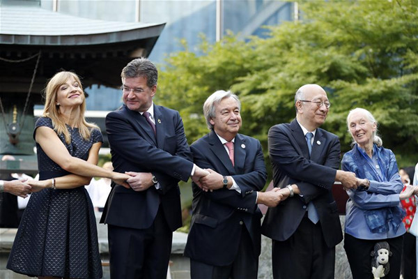 United Nations Secretary-General Antonio Guterres (C) poses for group photos with participants at a bell-ringing ceremony at UN headquarters in New York, Sept. 15, 2017. Guterres on Friday highlighted the plight of refugees and migrants and the need to end conflicts on the occasion to mark the International Day of Peace, or World Peace Day. The Peace Bell Ceremony is an annual ritual at the UN Headquarters, where the bell of peace is rung by the UN secretary-general for celebrations of the World Peace Day, which falls on Sept. 21. (Xinhua/Li Muzi)