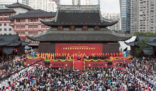 Tourists and monks attend a ceremony of gratitude at the Grand Hall of the Jade Buddha Temple in Shanghai on Sunday. The hall was moved 31 meters north and raised 1 meter. (Gao Erqiang/China Daily)