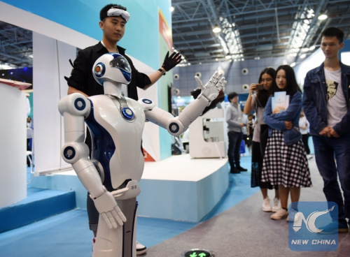 People look at a bionic robot at an exhibition during the 2017 national mass innovation and entrepreneurship week in Beijing, capital of China, Sept. 15, 2017. (Xinhua/Zhang Chenlin)