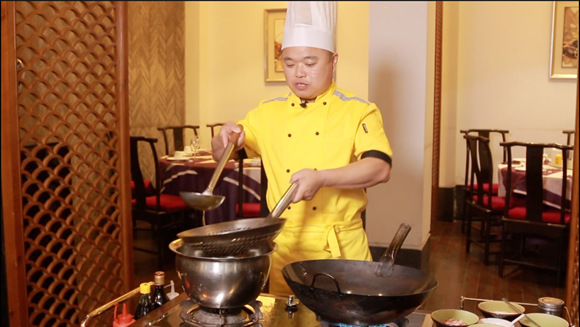 Chef Zhong prepares a Stinky Mandarin Fish,  his signature dish. (Photo‍/CGTN)