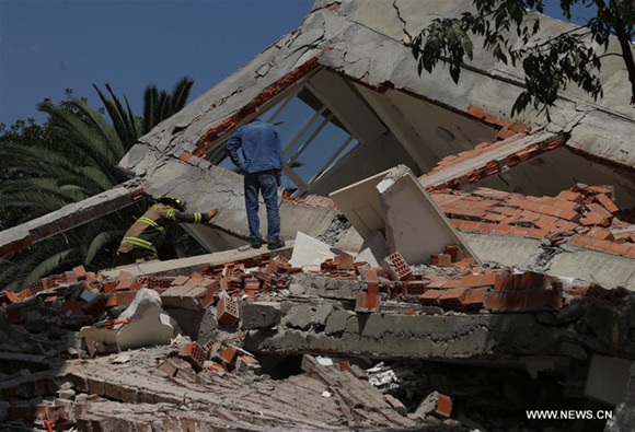 People inspect a collapsed building after an earthquake in Mexico City, capital of Mexico, on Sept. 19, 2017. (Xinhua/Fernando Ramirez)
