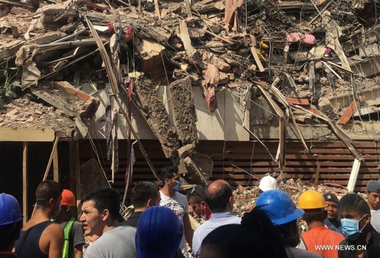 Image taken with a mobile phone shows people watching a collapsed building after an earthquake in Mexico City, capital of Mexico, on Sept. 19, 2017. (Xinhua/Xu Liang)