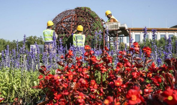 Workers install flower arrangements in Tian'anmen Square on Sept 18, 2017. Photo/Xinhua