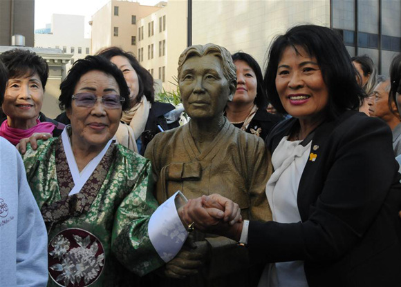 Korean comfort women survivor Yong-soo Lee(1st L) poses with a sculpture depicted Kim Haksoon, the first among the surviving comfort women to go public in front of television cameras about her story in August 1991, at St. Mary Square in San Francisco, the United States, on Sept. 22, 2017. Comfort Women Justice Coalition, a local grassroots advocacy group devoted to bring justice for the victims of Japanese military sexual slavery during the World War Two, unveiled a monument dedicated to the comfort women in San Francisco on Friday.(Xinhua/Ma Dan)