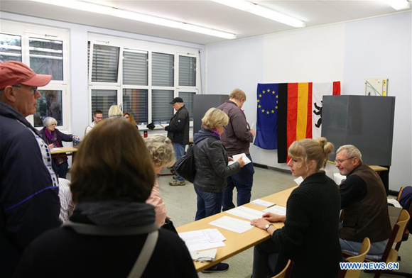 People are seen at a polling station in Berlin, Germany, on Sept. 24, 2017. More than 61 million German voters were called to cast ballots on Sunday to pick their Bundestag, or federal parliament, on which a new government will be formed. (Xinhua/Stefan Zeitz)