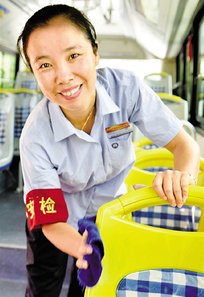 Chen Xia'na, a bus driver of Line 36 of the Ningbo Public Transportation Corp, wipes a seat on her bus. (Photo by Shui Guixian via Zhejiang Online)
