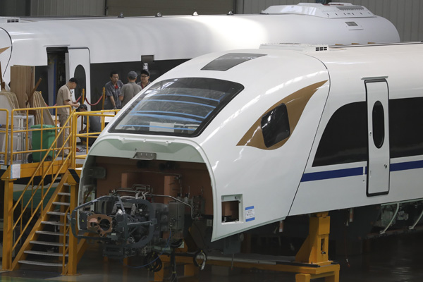 Workers assemble a train in a factory of CRRC Changchun Railway Vehicles Co in Changchun this month. (Photo by ZHU XINGXIN/CHINA DAILY)
