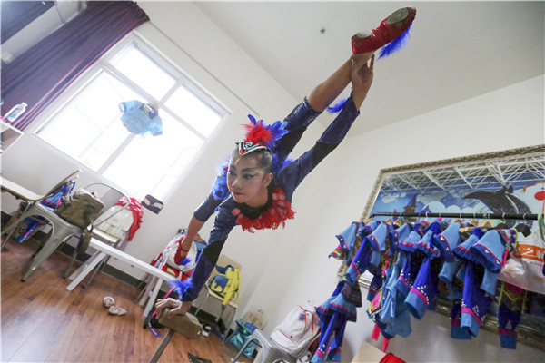 Young actress Wei Sina stretches her limbs before her acrobatic show at the 10th China Acrobatics Golden Chrysanthemum Awards held over Sept 16-21 in Penglai, Shandong province. (Photo by Wang Zhuangfei/China Daily)