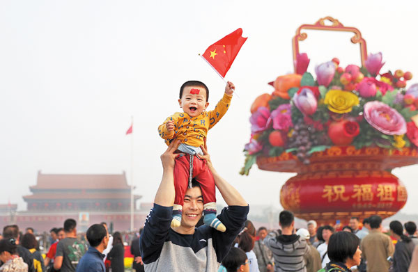 A young, enthusiastic visitor joins the crowd on National Day in Tian'anmen Square in Beijing on Sunday. Zou Hong / China Daily
