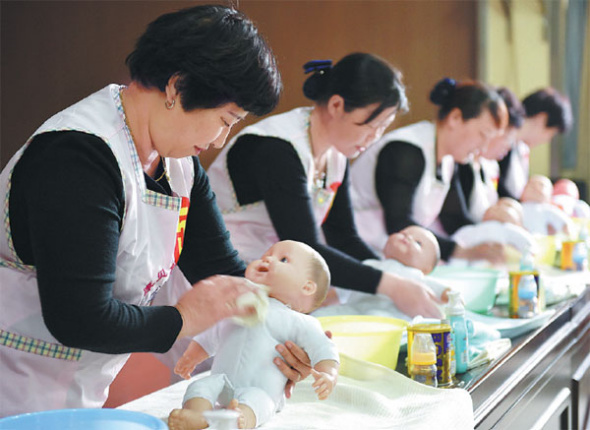 Maternity nurses participate in a baby care competition in Qinyang, Henan province, in April last year. Li Yafeng / For China Daily