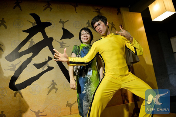 A visitor poses with the wax figure of actor Bruce Lee at the first wax museum in Selangor State, Malaysia, Aug. 15, 2013. (File photo: Xinhua/Chong Voon Chung)