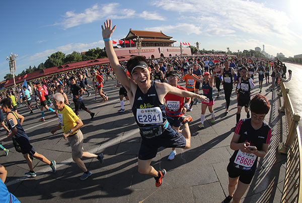 One runner has a real spring in his step as throngs of participants pass the Palace Museum during this year's Beijing Marathon on Sept 17. Underlining running's rising popularity in China, the race was massively oversubscribed with an online lottery required to determine the 30,000 starters. (SHENG JIAPENG/CHINA NEWS SERVICE)