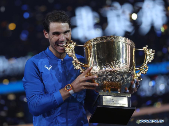 Rafael Nadal of Spain bites his trophy after winning the men's singles final against Nick Kyrgios of Australia at the China Open tennis tournament in Beijing, capital of China, on Oct. 8, 2017. (Xinhua/Meng Yongmin)