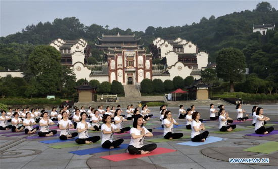 Yoga lovers practice yoga in the morning at a scenic spot in Zigui County, central China's Hubei Province, June 20, 2017. (Xinhua/Wang Jiaman)