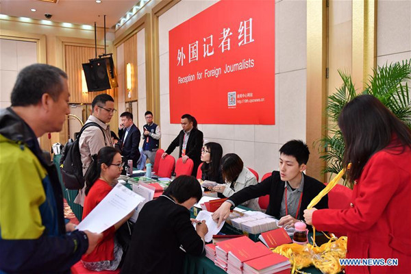 Staff members work at the reception for foreign journalists in the Press Center of the 19th National Congress of the Communist Party of China in Beijing, capital of China, Oct. 11, 2017. The press center based in the Beijing Media Center Hotel began operations on Wednesday. (Xinhua/Li Xin)