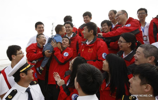 Shi Xing'an (2nd R, rear), a member of the Chinese scientific expedition team, is welcomed by his son upon his return in Shanghai, east China, Oct. 10, 2017. China's ice breaker, the Xuelong (Snow Dragon) returned to base in Shanghai Tuesday after 83 days on the Arctic rim, completing its eighth Arctic expedition. (Xinhua/Fang Zhe)
