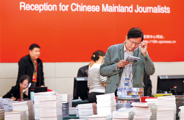 A staff member goes through materials at the Press Center of the 19th National Congress of the CPC in Beijing Media Center Hotel on Wednesday. (FENG YONGBIN / CHINA DAILY)