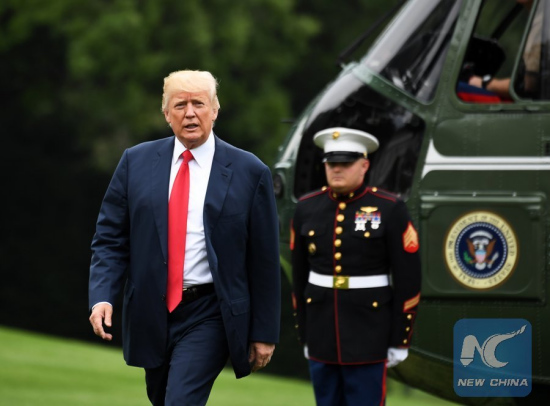 File Photo: U.S. President Donald Trump (L) walks to his office from Marine One as he returns to the White House in Washington D.C., the United States, on Aug. 14, 2017. (Xinhua/Yin Bogu)