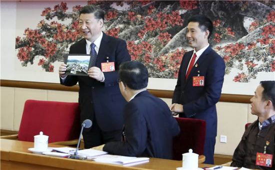 General Secretary Xi Jinping is given a panoramic photograph of the village of Huamao in Zunyi by the village's Party chief. Xi received it during a panel discussion with delegates from Guizhou province on Thursday at the ongoing 19th National Congress of the Communist Party of China in Beijing.LAN HONGGUANG / XINHUA
