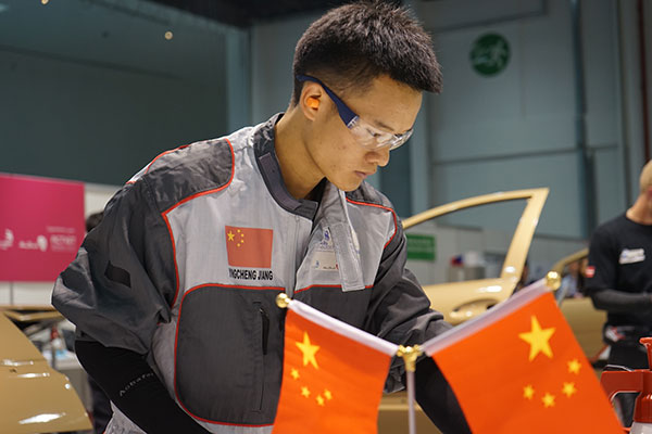 Jiang Yingcheng, a teacher from Hangzhou Technician Institute, competes in the car spraying event at the 44th WorldSkills Competition, which closed in Abu Dhabi, United Arab Emirates, on Thursday. Jiang won the gold medal. Xu Junyong / For China Daily
