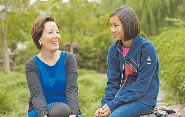 Sun Dingyi and her Dutch adoptive mother Petra de Vaal chat in a garden in Shanghais Jiading District. In a bid to fulfill Suns long-held wish to find her birth parents, the pair have traveled nearly 9,000 kilometers to the city where she was abandoned shortly after her birth. Yesterday they visited the Juyuan police station in Jiading to have Suns DNA collected for a possible future match. The girl was left at Jiading District Central Hospital two days after she was born on November 15, 2007. Sun then spent the next 22 months of her life at Shanghai Childrens Welfare Service Center until she was adopted. She had been born with a left ear deformity. Her Dutch family raised her in a small village about 20km from Utrecht in the center of the Netherlands. (Jiang Xiaowei)