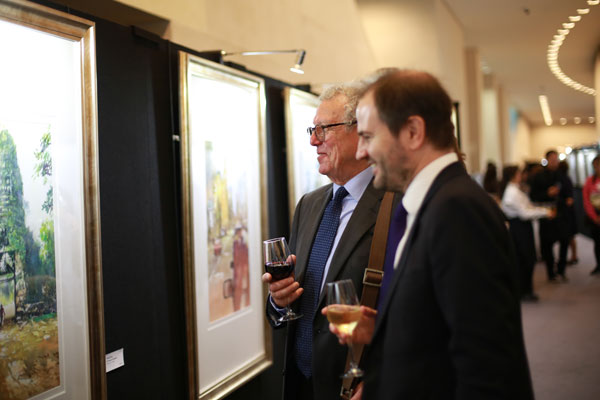 The president of Royal Society of British Artists, Nick Tidnam (left), views Chinese watercolor artist Feng Sixiao's works at British Museum in London on Tuesday. (Photo provided to China Daily)