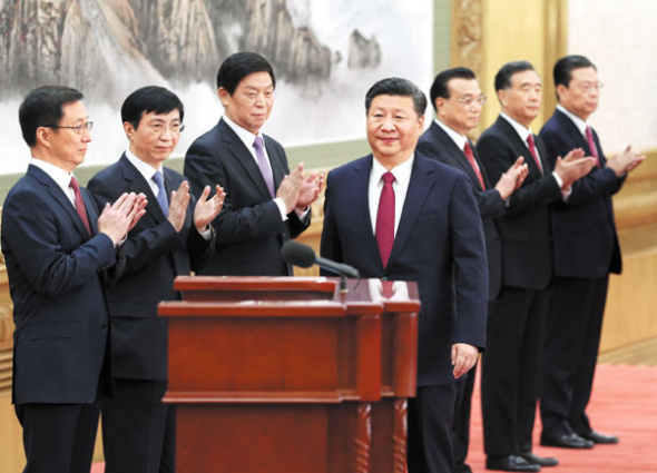 Other members of the new Standing Committee of the Political Bureau of the CPC Central Committee applaud General Secretary Xi Jinping as he prepares to address reporters at the Great Hall of the People in Beijing on Wednesday. (Photo: China Daily/Wu Zhiyi)