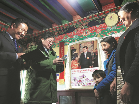 Tibetan sisters Yangzom (first right) and Zhoigarlisten to two government officials relaying an answer from President Xi Jinping to a letter the sisters wrote to him. The sisters live in Yumai in Lhunze county along the Himalayas' foothills. (CHANG CHUAN / FOR CHINA DAILY)