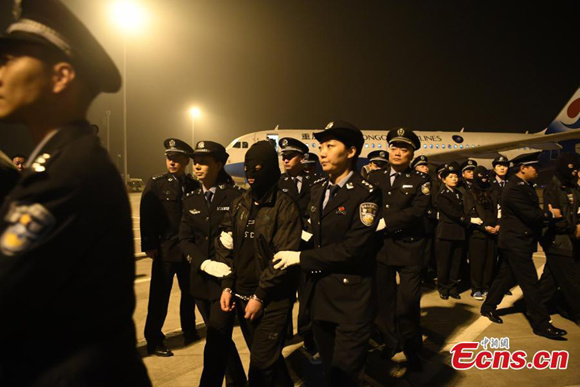 Chinese nationals suspected of involvement in transnational telecom fraud and deported from Cambodia arrive at an airport in Southwest Chinas Chongqing Municipality, Oct. 29, 2017, under the escort of Chinese police. (Photo: China News Service/Chen Chao)