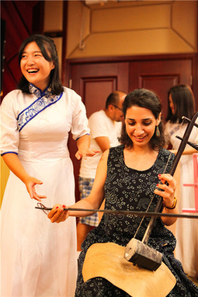 A young Sinologist learns to play the musical instrument erhu in Wuyuan, Jiangxi.(Photo by Lan Jian/For China Daily)