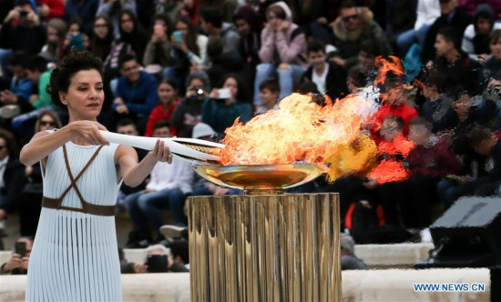 Actress Katerina Lehou playing the role of high priestess lights an Olympic torch during the handover ceremony for the Olympic Flame at Panathenaic stadium in Athens, on Oct. 31, 2017. (Xinhua/Marios Lolos)