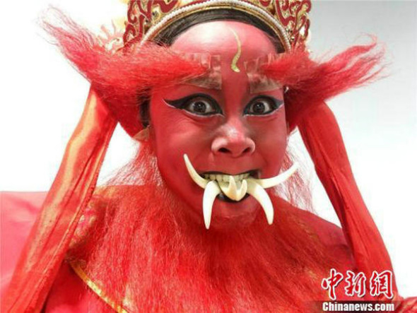 Artist Xue Qiaoping shows teeth playing. (Photo/Chinanews.com)