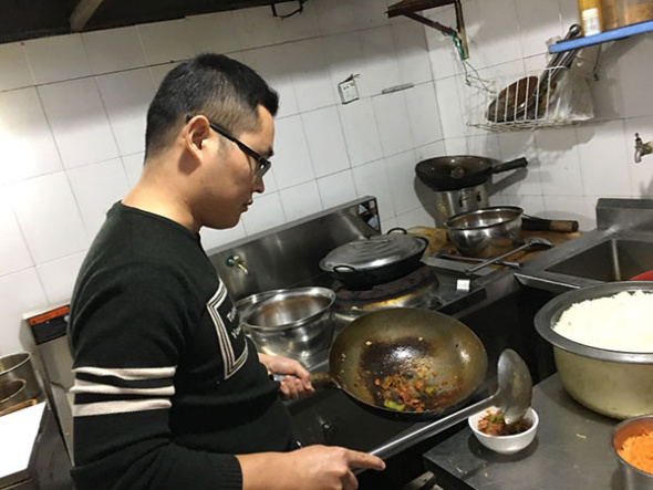 Si Shaojie, 30, cooks at his Desi Food restaurant. (Photo by Qi Xin/chinadaily.com.cn)
