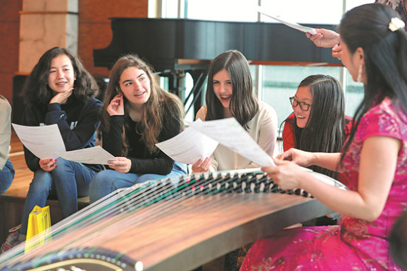 A musician teaches U.S. students about the guzheng, or Chinese zither, during an event at the Chinese Consulate General in New York in May. Culture is just one of the areas in which China and the United States have close relations. (WANG YING / XINHUA)