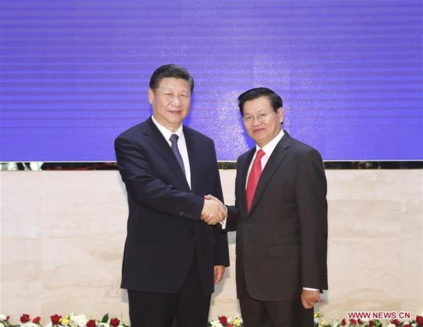 Chinese President Xi Jinping (L), also general secretary of the Communist Party of China Central Committee, shakes hands with Lao Prime Minister Thongloun Sisoulith during their meeting in Vientiane, Laos, Nov. 14, 2017. (Xinhua/Ding Lin)