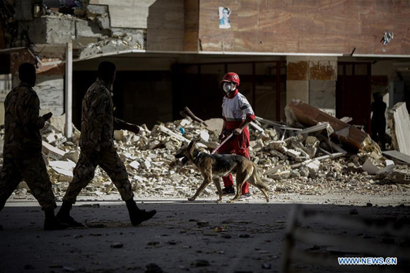 Rescuers search for survivors in front of damaged buildings in Sarpol-e Zahab, Iran, Nov. 13, 2017. (Xinhua/Ahmad Halabisaz)