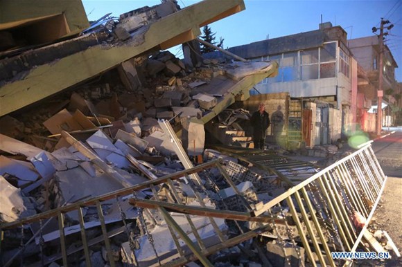 A local resident inspects a collapsed building in the town of Darbandikhan, Sulaimaniyah province, northern Iraq, on Nov. 13, 2017. (Xinhua/Ahmad Halabisaz)