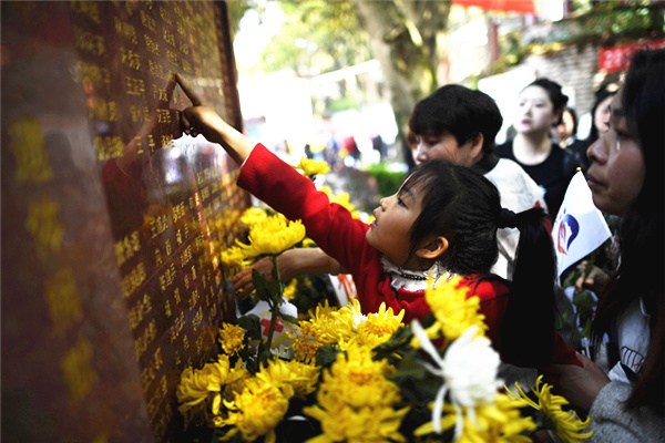 Children read the names of donors at the opening of a memorial park in Chongqing, Southwest China, on April 1. (Photo provided to China Daily)
